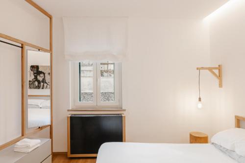 a bedroom with a bed and a tv and a window at Ai Maestri Rooms&Cafè in Matera