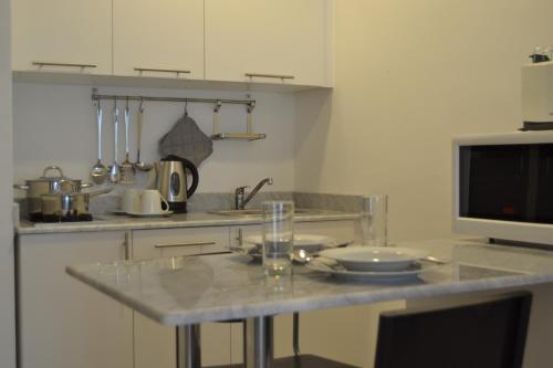 a kitchen with a counter top and a tv at Sedra Residence in Kuwait