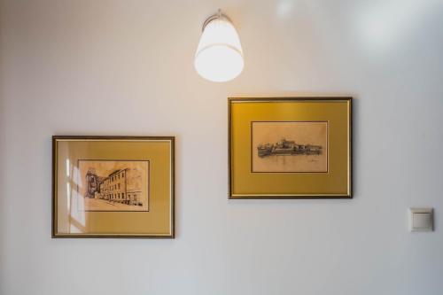 three framed drawings of buildings on a white wall at Piernikowy Domek in Toruń