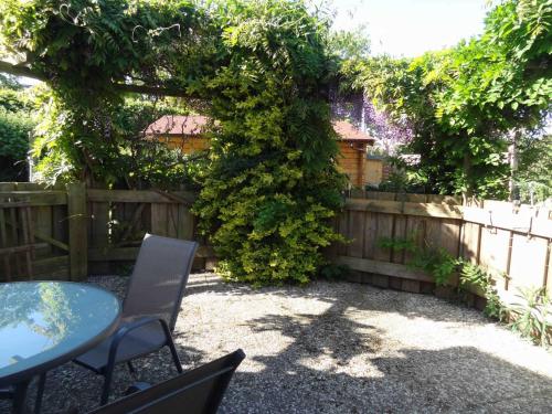 a patio with a table and chairs next to a fence at Heidelberg Viola in Neustadt in Holstein