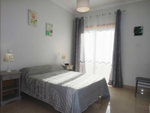 ラゴスにあるConvento Apartmentのベッドと大きな窓のある寝室