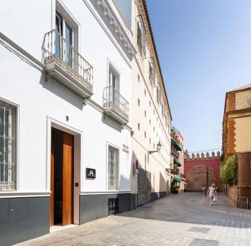 una calle en una ciudad con edificios blancos en La Puerta de Palacio - Adults Only, en Sevilla