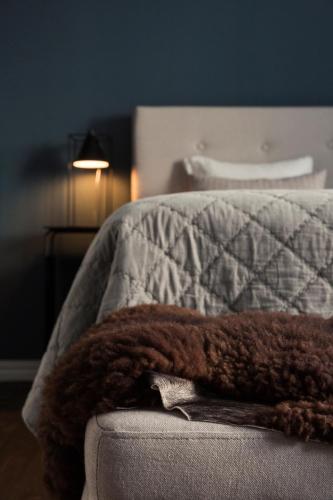 a brown blanket sitting on the edge of a bed at Stilleben Hotell in Åmot