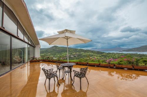 Rõdu või terrass majutusasutuses StayVista's Glass House - Villa with scenic lawn and mountain views