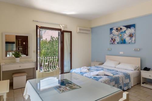 una camera con letto e tavolo in vetro di Byron Hotel ad Argostoli