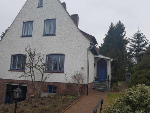 a white house with a blue door and windows at Horn Ingrid in Neustadt in Holstein