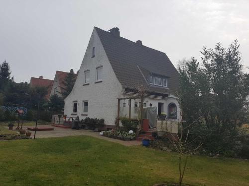 a white house with a black roof and a yard at Horn Ingrid in Neustadt in Holstein