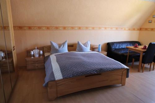 um quarto com uma cama, uma cadeira e uma mesa em Ferienwohnung-Deichgraf em Westerland