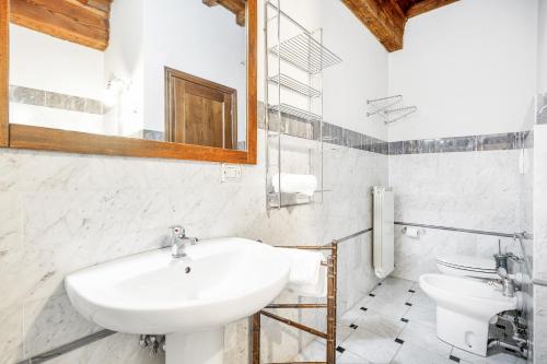 biała łazienka z 2 umywalkami i lustrem w obiekcie San Lorenzo Wooden Loft we Florencji
