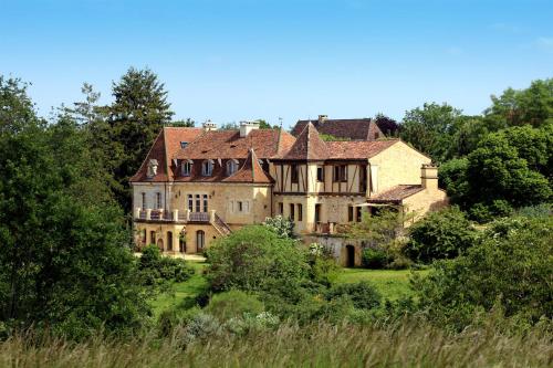 ein altes Haus auf einem Hügel mit Bäumen in der Unterkunft Domaine du Fraysse Chantegrel le charme à l'etat pur in Saint-Cybranet