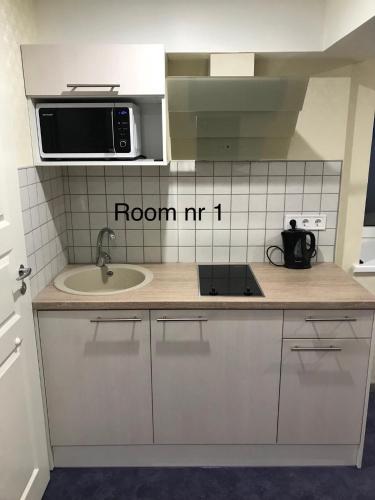 a kitchen with a microwave and a sink at Liivalaia 40 cozy kitchen studio in Tallinn