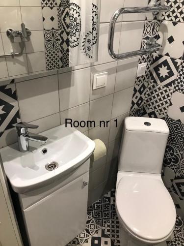 a bathroom with a white toilet and a sink at Liivalaia 40 cozy kitchen studio in Tallinn