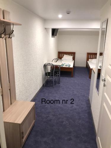 a room with two beds and a table and chairs at Liivalaia 40 cozy kitchen studio in Tallinn