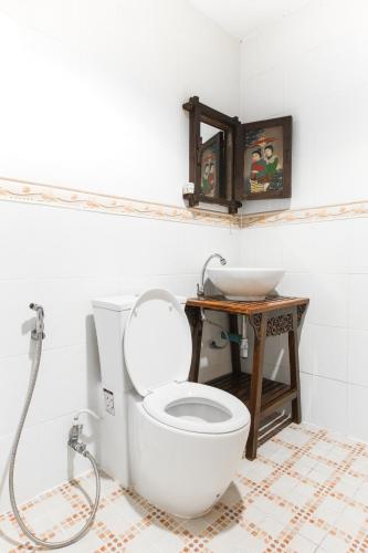 a bathroom with a white toilet and a sink at SK Boutique Mahanakhon in Bangkok