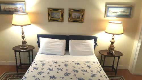 Paola A Trastevere في روما: غرفة نوم بها سرير مع مصباحين