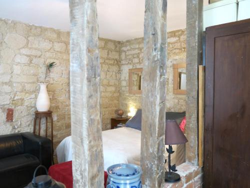 - une chambre avec un lit dans une pièce dotée de murs en pierre dans l'établissement Montmartre Del Sarte Cosy CityCosy, à Paris