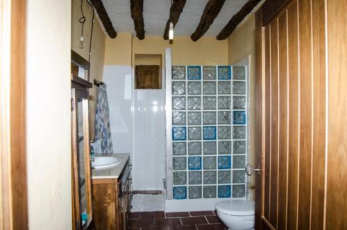 a bathroom with two sinks and a toilet and a shower at Casas rurales Santa Ana de la sierra in Santa Ana