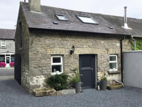 a stone house with a black door and windows at The Stone House, Multyfarnham in Multyfarnham