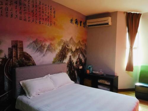a bedroom with a bed with a painting on the wall at Home Inn Hotel in Ipoh