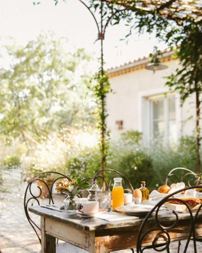 an outdoor table with a breakfast of food and orange juice at La Casa de los Tomillares in Candeleda