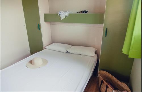 a small room with a bed with a hat on it at Camping Sènia Caballo de Mar in Pineda de Mar