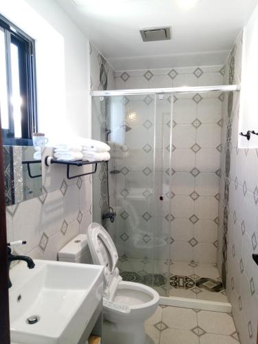 a bathroom with a shower and a toilet and a sink at 小時公館城西 in Yuli