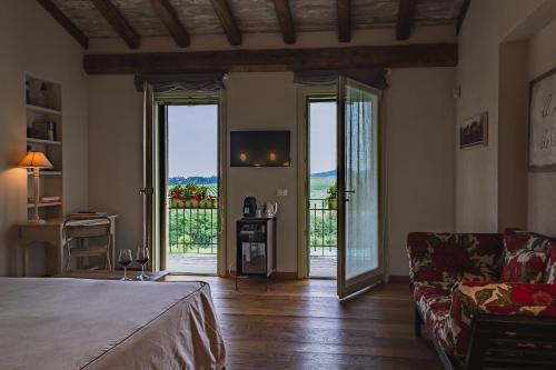 een slaapkamer met een bed, een bank en een balkon bij Prime Alture Wine Resort in Casteggio