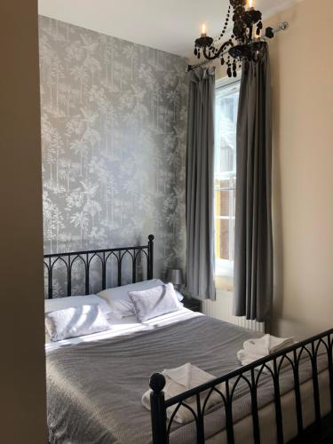 a bedroom with a bed and a wall with wallpaper at The Dorset in Lewes