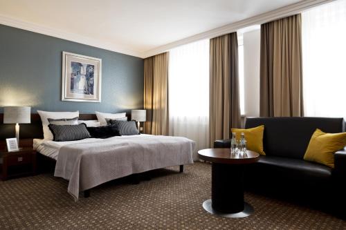 a hotel room with a bed and a couch at Hotel Tarnovia in Tarnów