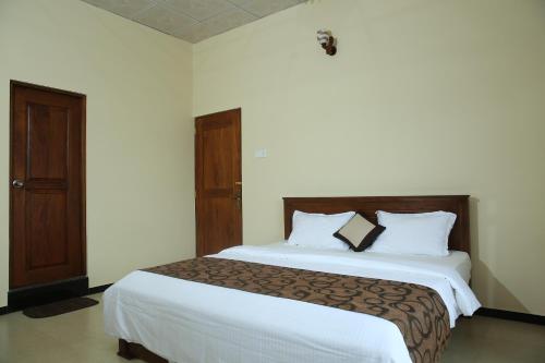 a bedroom with a large bed with white sheets at Mount View Bungalow in Hatton