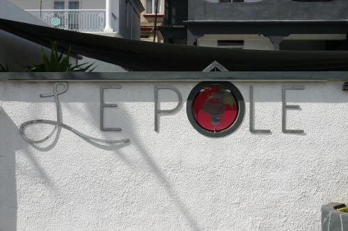 a sign on a wall with a red mirror at Le Pôle in Grand Baie