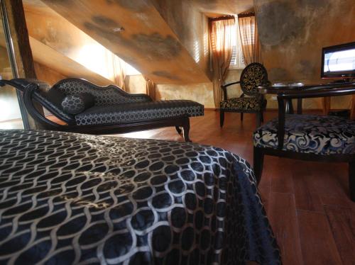 a bedroom with a bed and two chairs and a desk at Boutique Hotel Astoria in Kotor