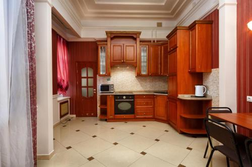 a kitchen with wooden cabinets and a stove top oven at Hostel Suputnyk in Lviv