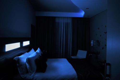 a dark room with a bed and a window at Hudson House in Pretoria