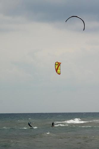 two people in the ocean flying a kite at Apartments and Rooms Degra in Umag