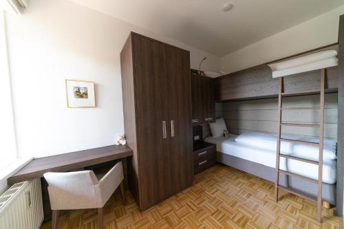 a small bedroom with a bunk bed and a desk at Villa zur Schmied'n in Ehrenhausen