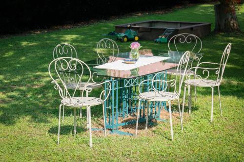 a table with four chairs and a vase on it at Villa zur Schmied'n in Ehrenhausen
