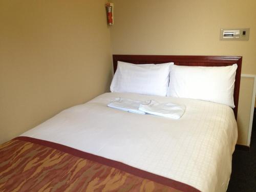 a bed with two white towels on top of it at Hotel Horidome Villa in Tokyo