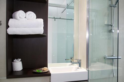 a bathroom with a sink and a shower and towels at The Z Hotel Liverpool in Liverpool
