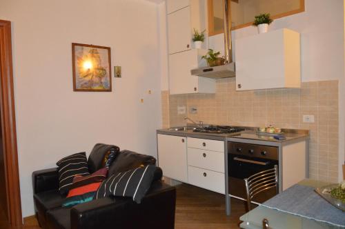 een keuken met een bank en een fornuis top oven bij Appartamento La Maddalene in Pisa