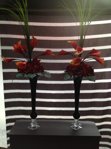 two vases with flowers in them on a table at Hotel Horidome Villa in Tokyo