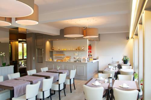 ein Restaurant mit Tischen und Stühlen und eine Küche in der Unterkunft Hotel De Golf in Bredene