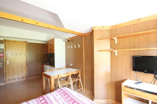 a room with a bed and a kitchen with a table at Artuik Appartamenti Montana in Marilleva