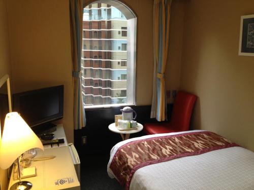 Habitación de hotel con cama y ventana en Hotel Horidome Villa, en Tokio