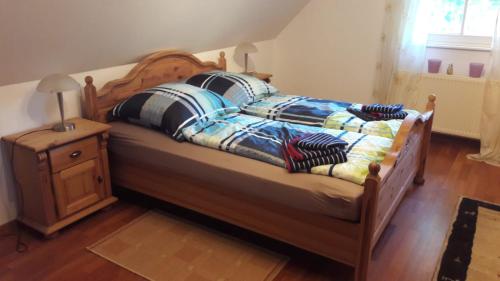 ein Bett mit zwei Kissen darauf mit einem Nachttisch in der Unterkunft Austernfischer in Reitland