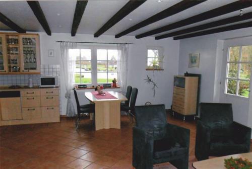 uma cozinha com mesa e cadeiras num quarto em Austernfischer em Reitland