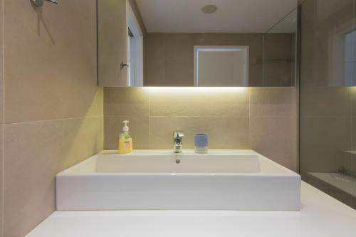 uma casa de banho com um lavatório branco e um espelho. em Best Seaview Attica em Saronida