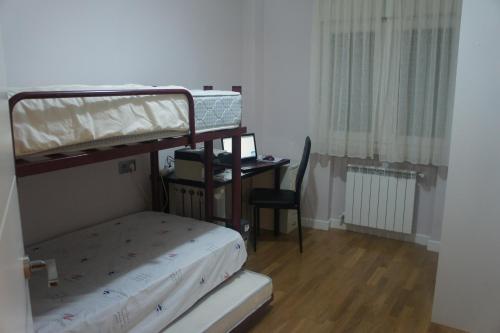 a small room with a bunk bed and a desk at Apartamento La Paz de Versalles in Avilés