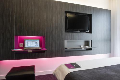 a room with a laptop and a tv on a wall at Akena Nantes Atlantis Zénith in Saint-Herblain