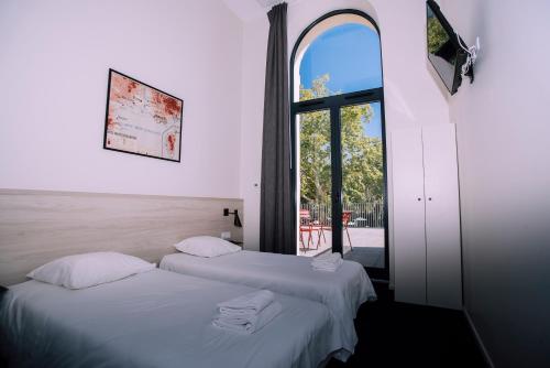 two beds in a room with a window at Villages Clubs du Soleil - MARSEILLE in Marseille